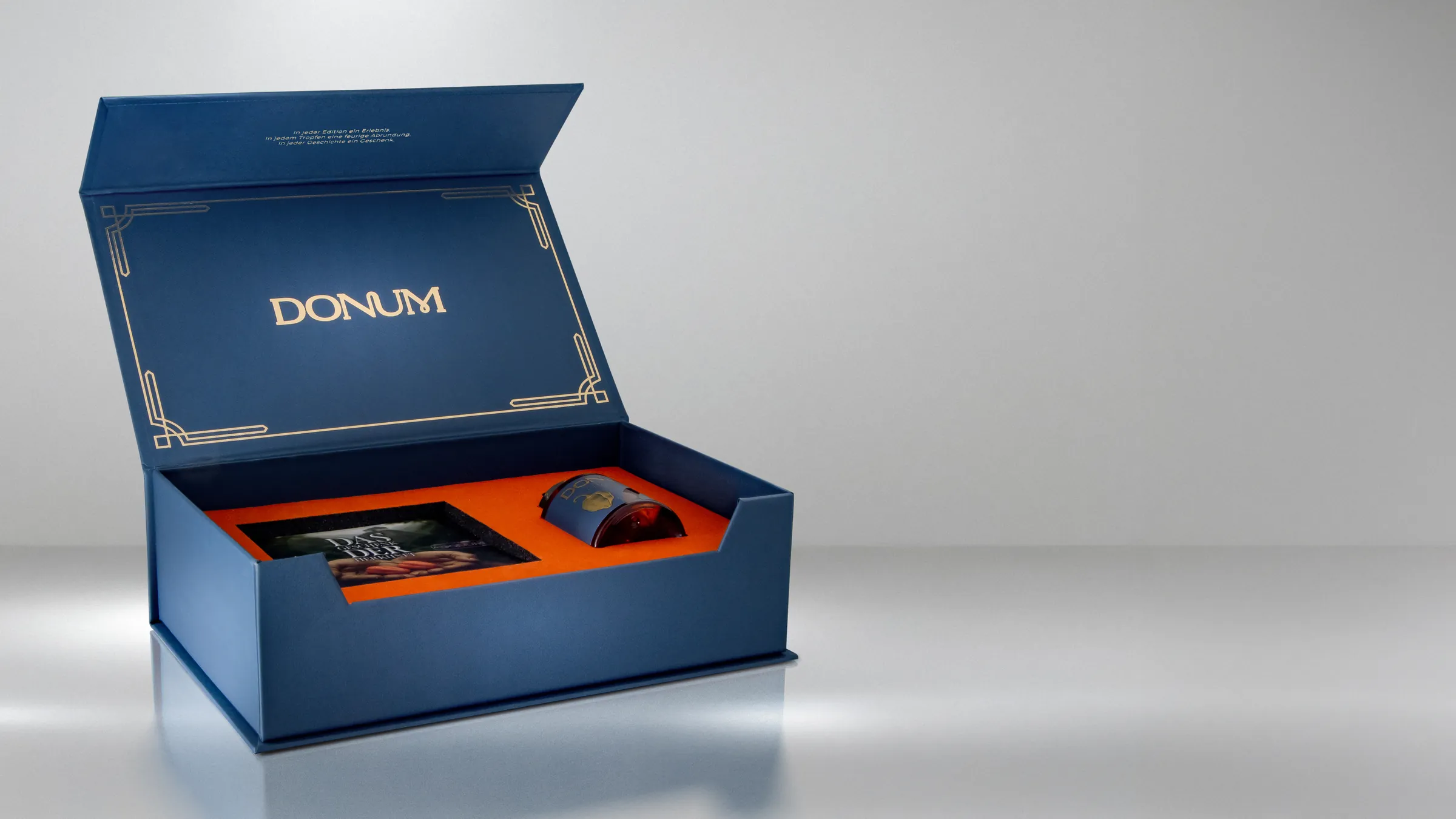The opened DONUM gift box with booklet and inset flacon