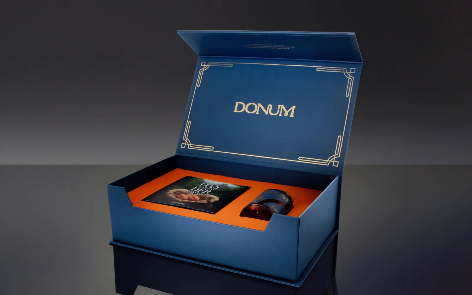 The opened DONUM gift box of the Black Edition with booklet and flacon